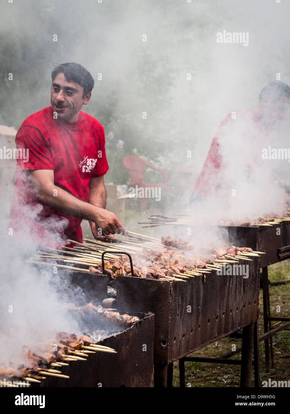 Géorgiens préparer un de leurs plats nationaux, l'mtsvadi (grillades brochette de viande), sur les jeunes Festival du vin à Tbilissi. Banque D'Images