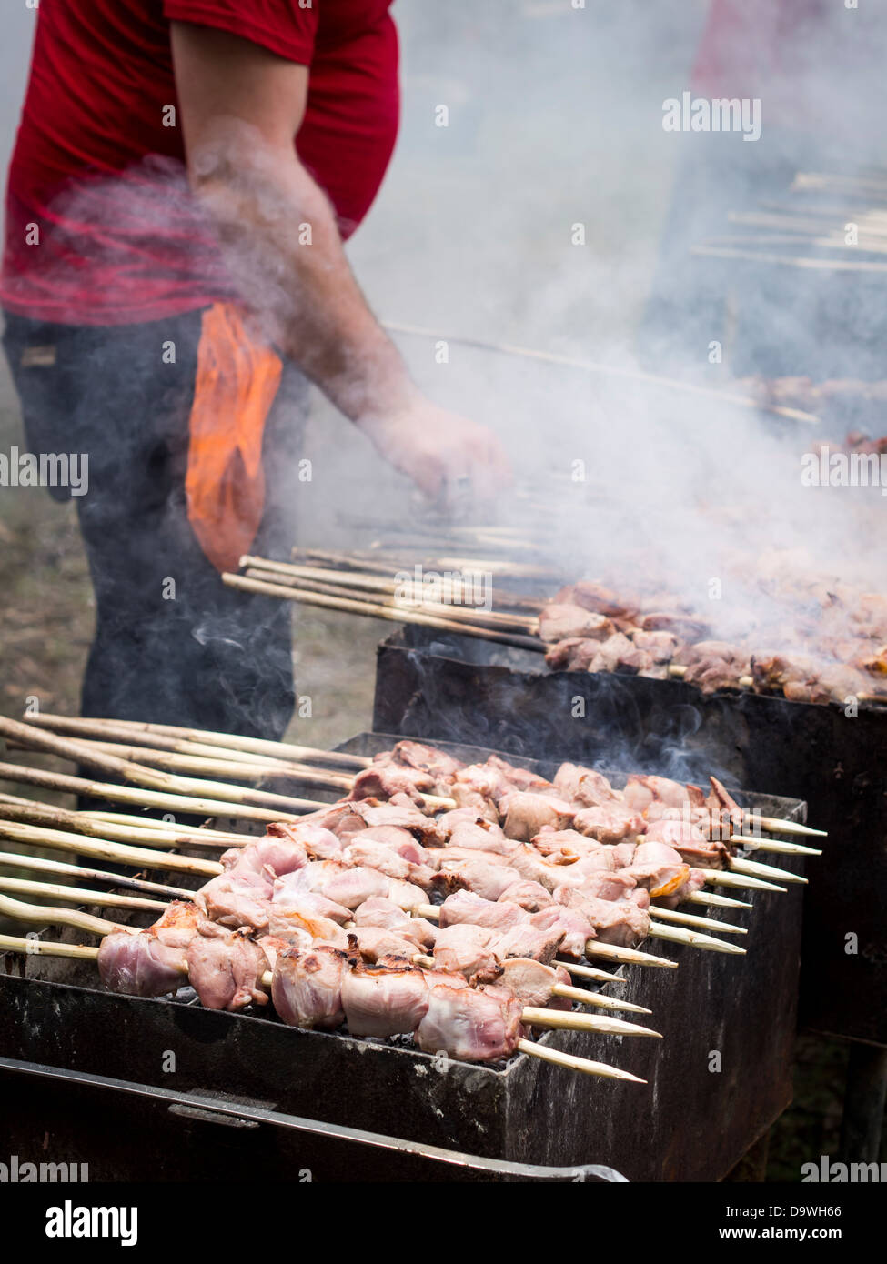 Géorgiens préparer un de leurs plats nationaux, l'mtsvadi (grillades brochette de viande), sur les jeunes Festival du vin à Tbilissi. Banque D'Images