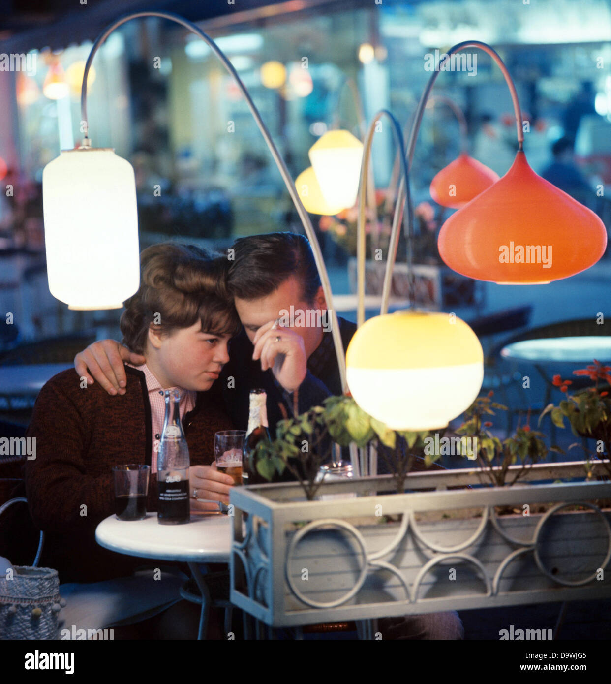 Les jeunes amoureux ont un coca et de la bière dans un bar à Frankfurt am Main, photographiés dans les années 1970. Banque D'Images