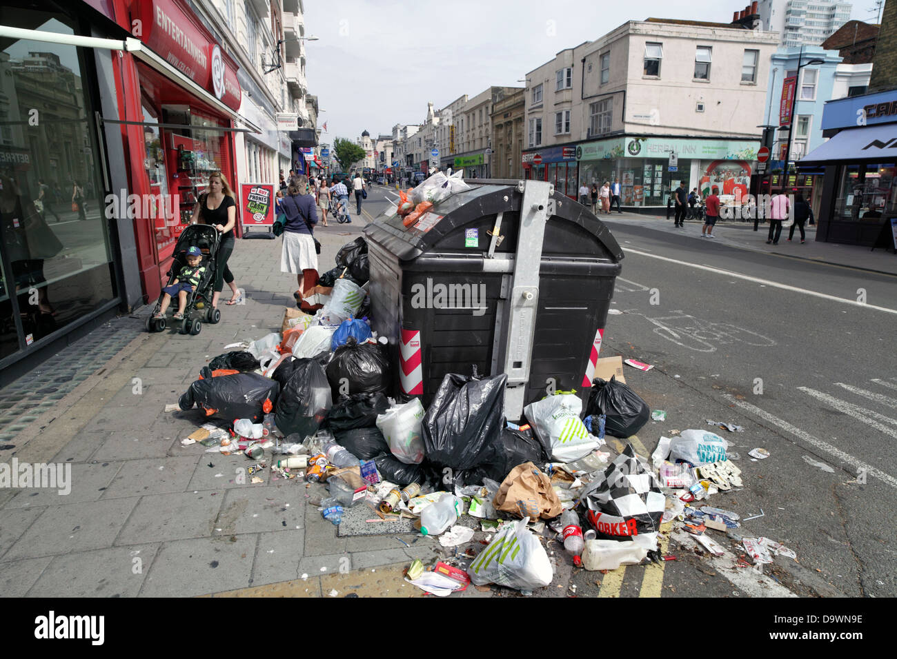 Des tas de détritus autour de la poubelle, Brighton city centre. Banque D'Images