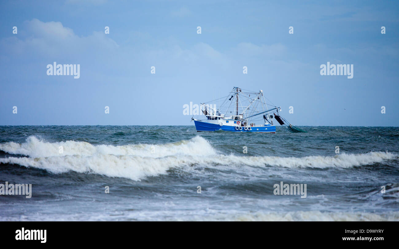 Bateau de crevettes filet traînant dans une mer Banque D'Images