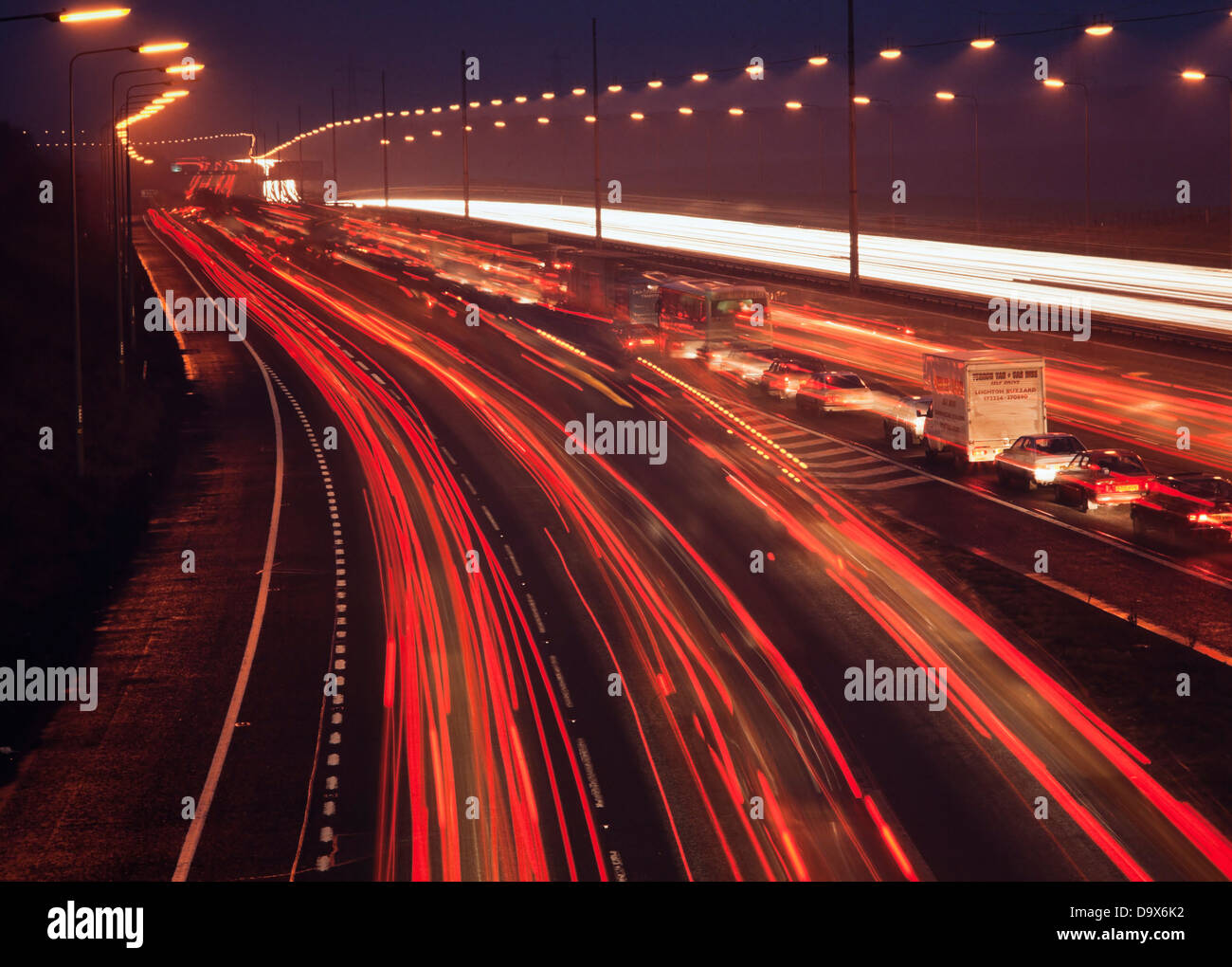 Le trafic de banlieue d'autoroute sur l'autoroute M1 dans la nuit ou en fin de soirée, UK Banque D'Images