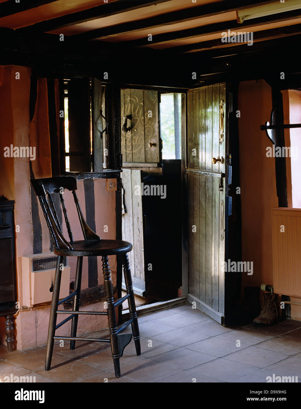 Mobilier chaise haute en salle Tudor cottage avec porte de l'écurie et carrelage Banque D'Images