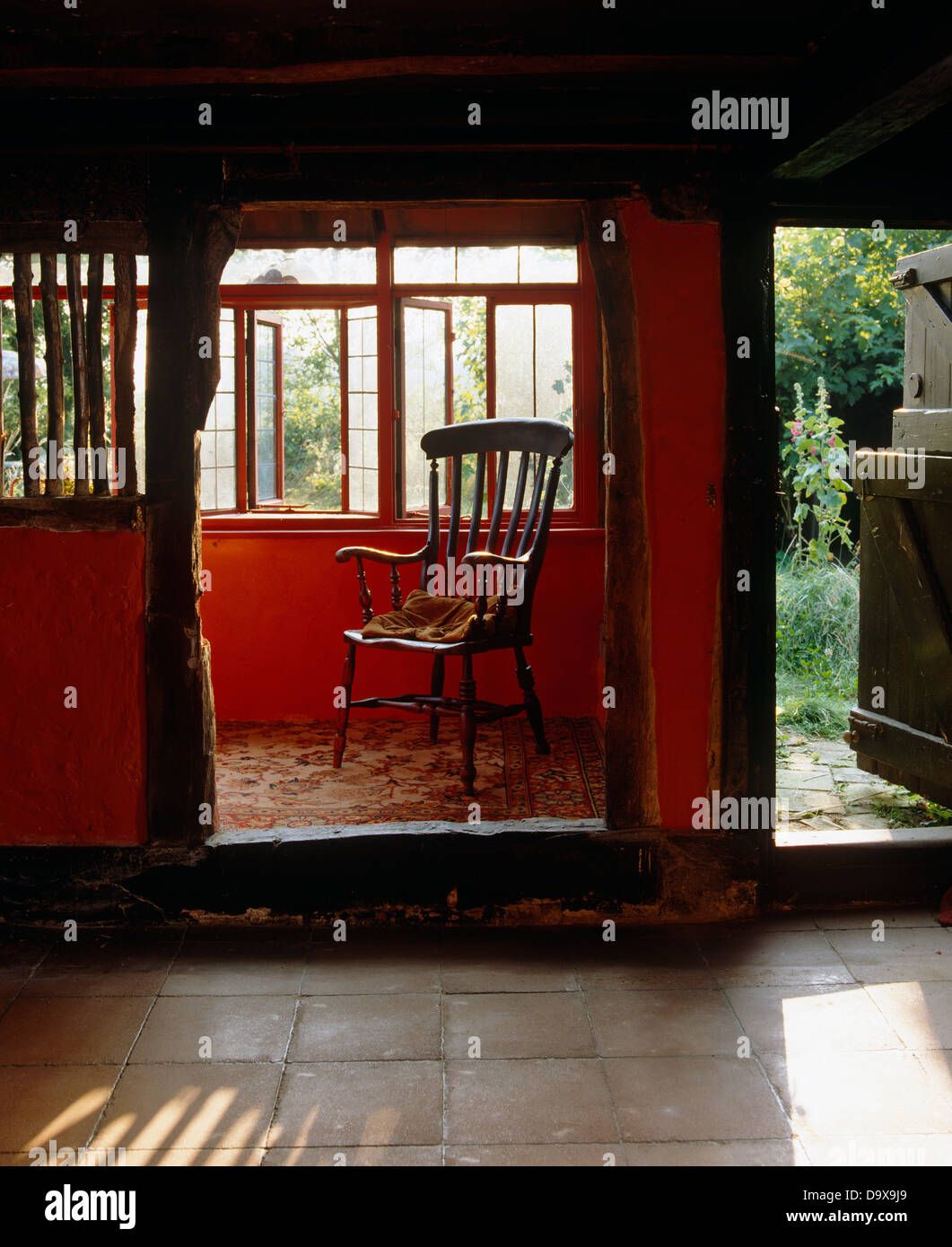 Chaire en chêne et des poutres en bois dans le couloir de style Tudor cottage stable avec porte avant ouverte au jardin Banque D'Images