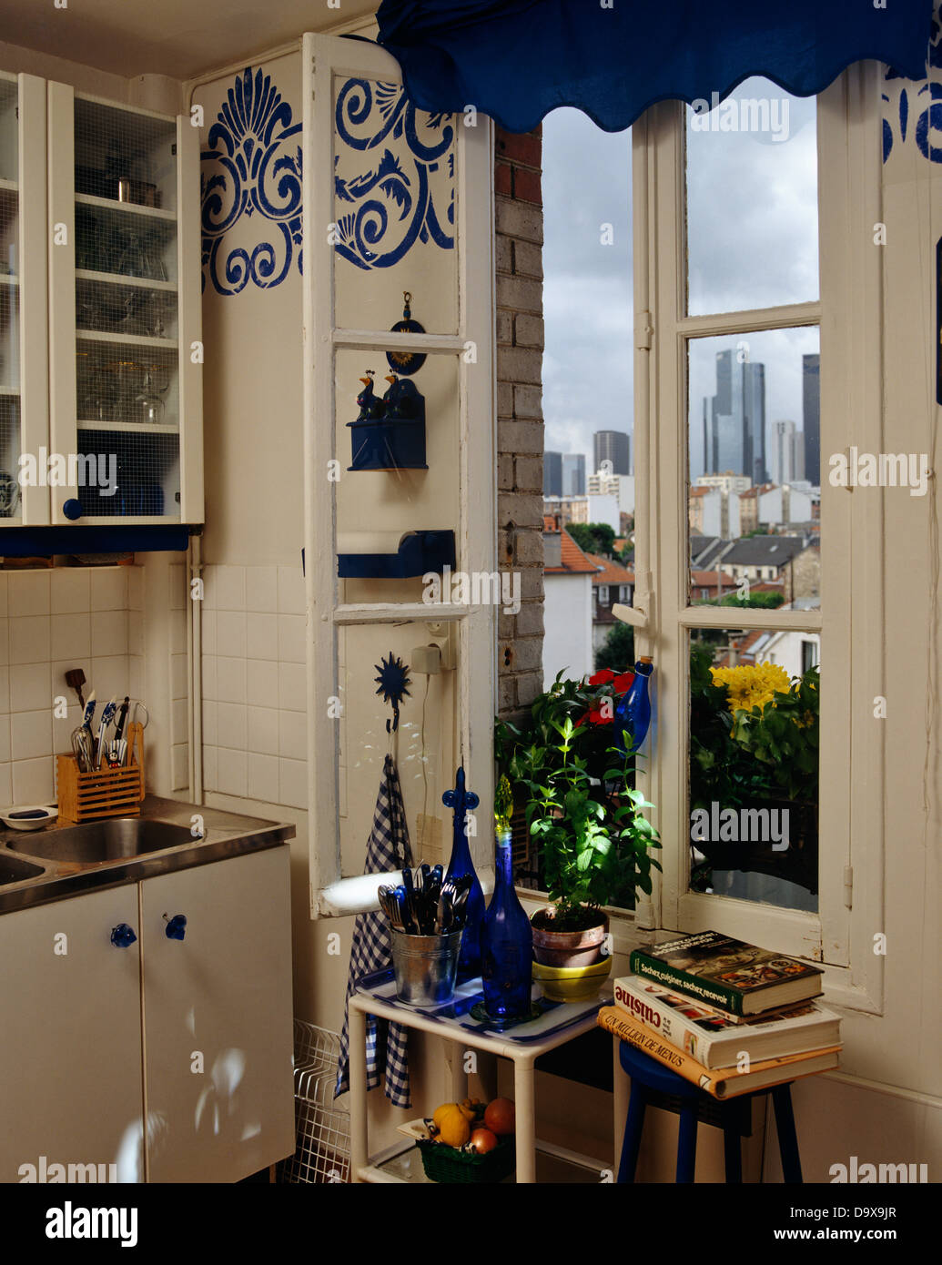 Verrerie bleu sur une petite table dans le cadre de fenêtre dans coin de  cuisine maison traditionnelle avec vue sur la ville Photo Stock - Alamy