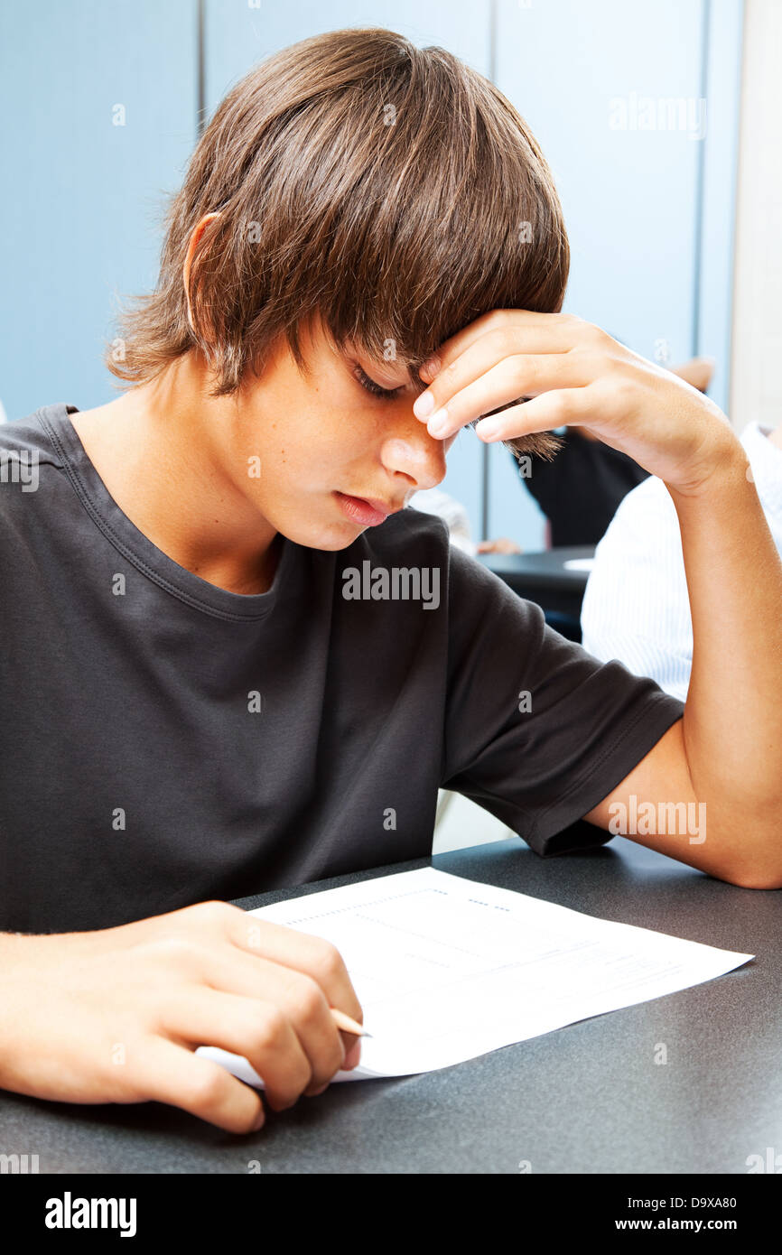 Teen boy en prenant un test objectif à l'école et inquiets de l'issue. Banque D'Images