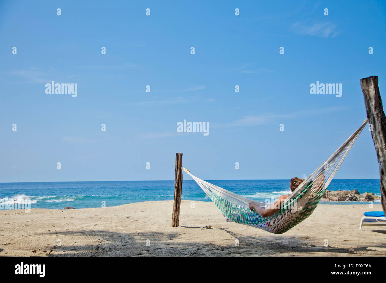 Jeune homme dans le hamac sur la plage Banque D'Images Jeune homme dans le hamac sur la plage Banque D'Images