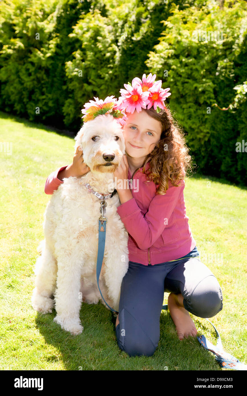 Teen girl et chien blanc portant des fleurs Banque D'Images