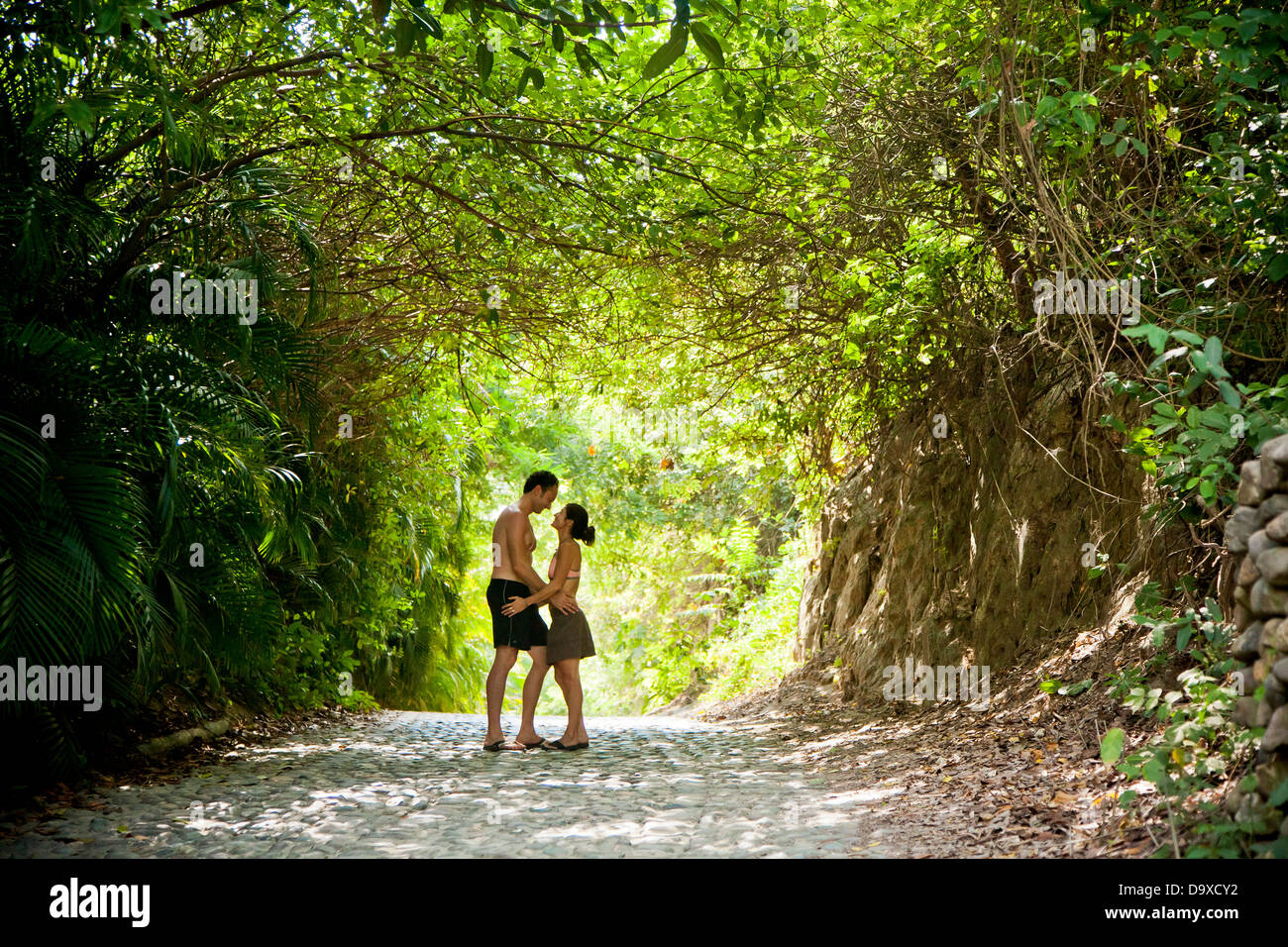 Couple walking down tree chemin voûté Banque D'Images
