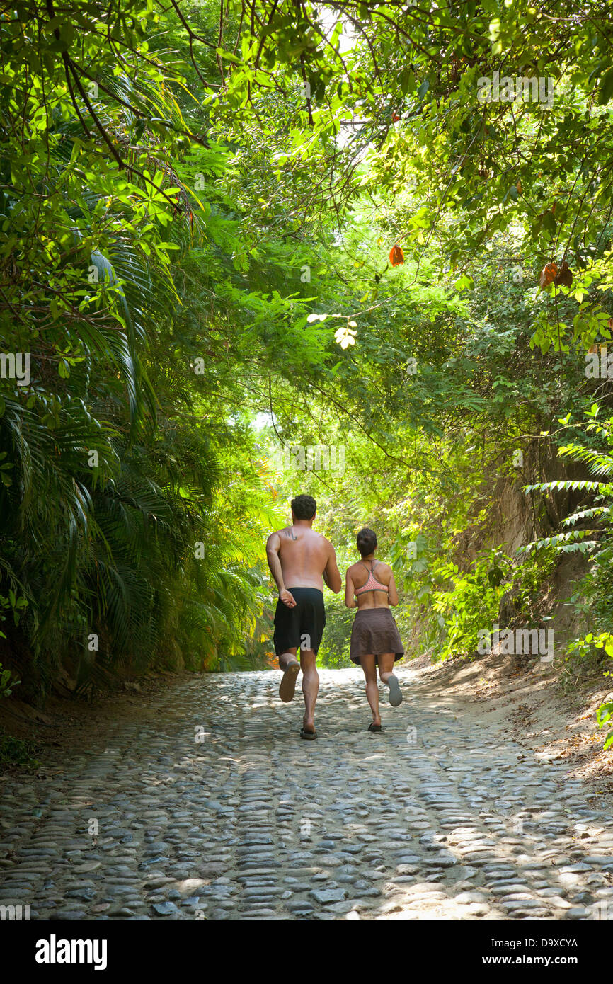 Couple walking down tree chemin voûté Banque D'Images Couple walking down tree chemin voûté Banque D'Images