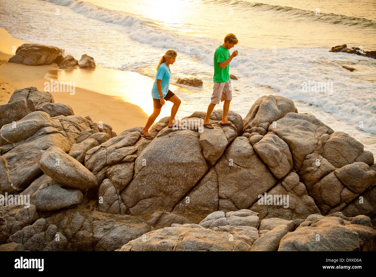 Couple hiking on beach rocks Banque D'Images
