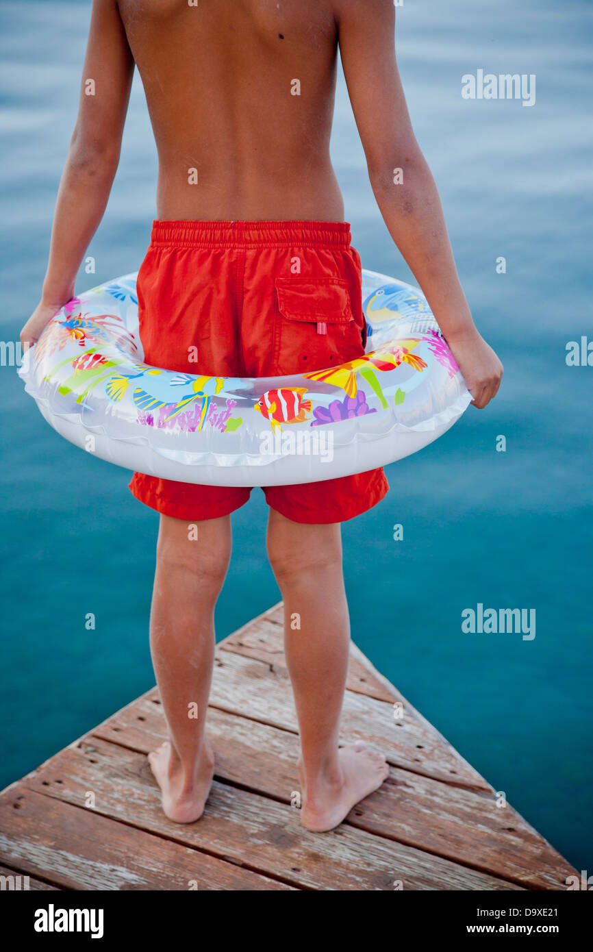 Jeune garçon portant la bague flottante on dock Banque D'Images
