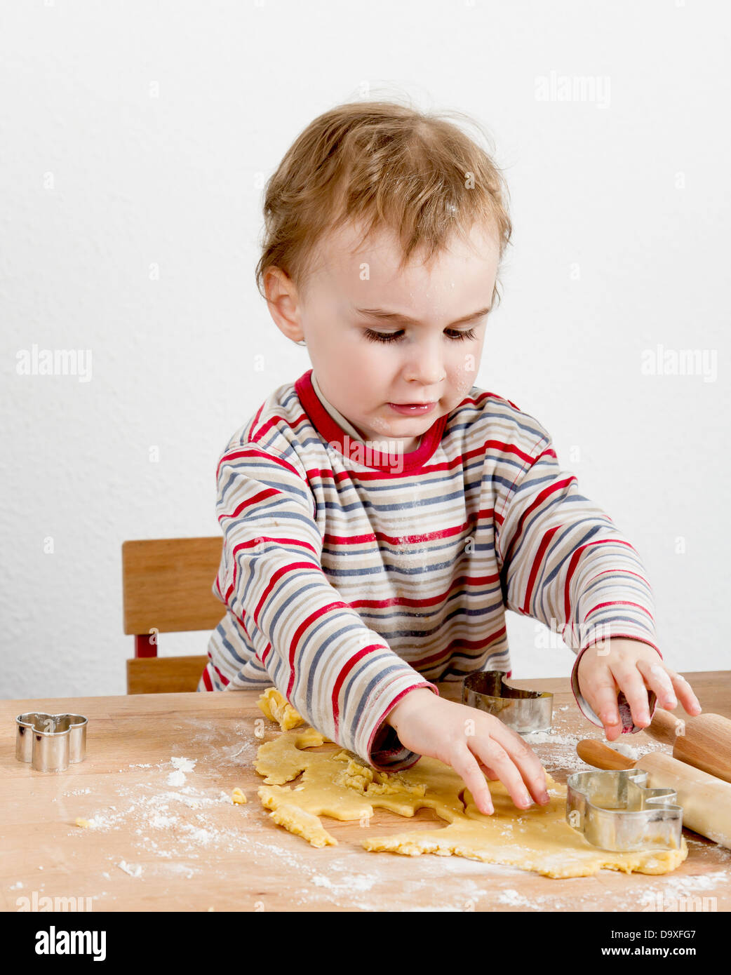 Enfant à des cookies d'un bureau en bois verticale de l'image. Banque D'Images