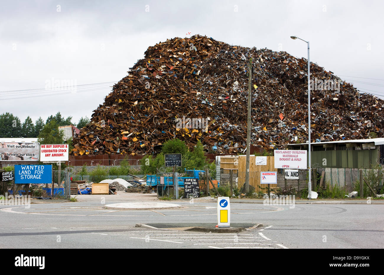 Gros tas de ferraille avec des signes sur le chemin public en premier plan, Widnes, Cheshire, Angleterre Banque D'Images