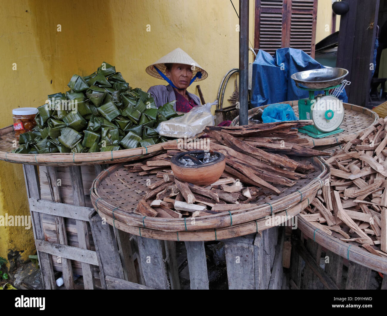 L'opérateur de marché la vente du bois d'encens brûlant. Hoi An, Vietnam. Banque D'Images