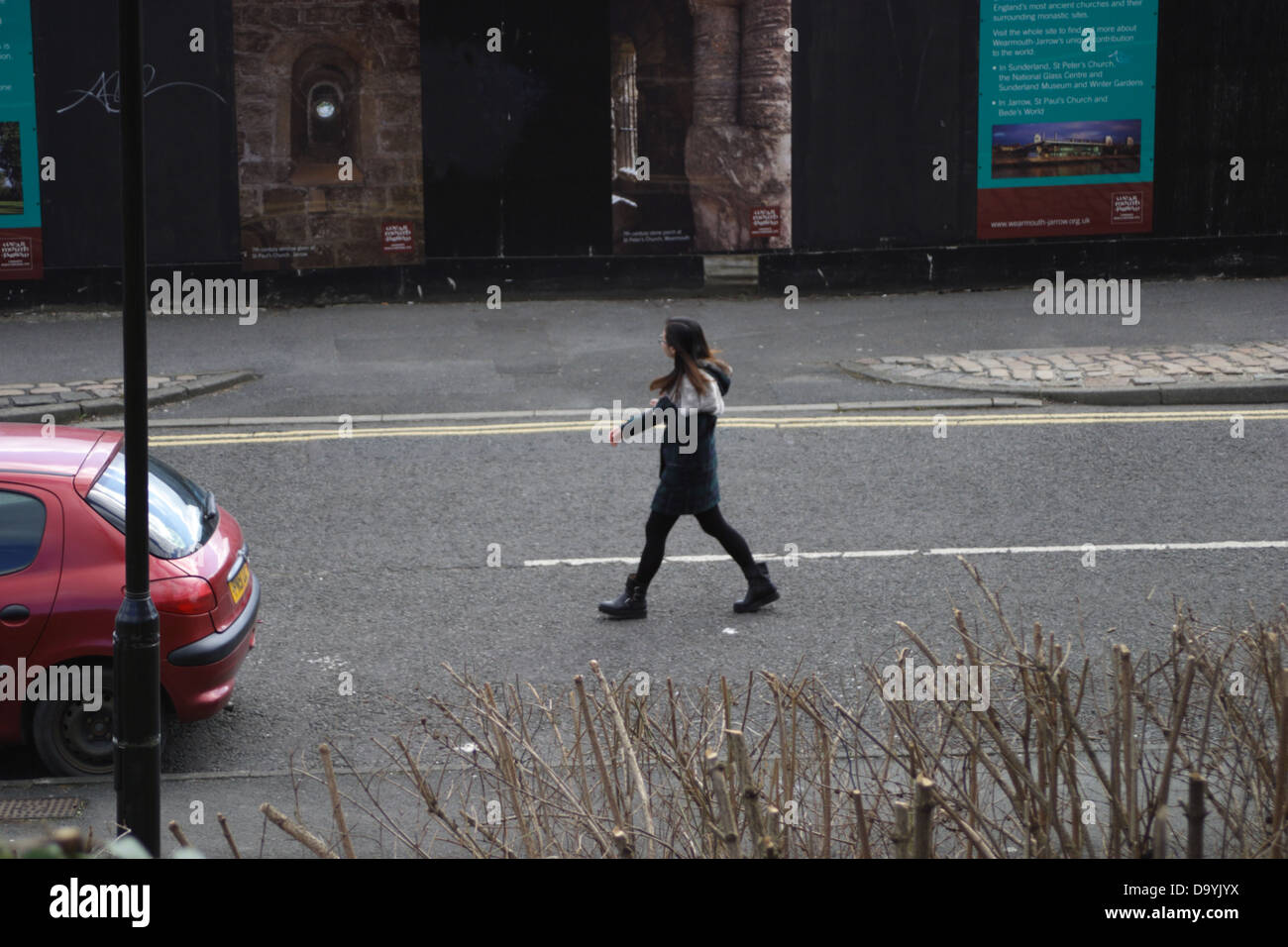 Jeune femme marchant dans le milieu de la route. Banque D'Images