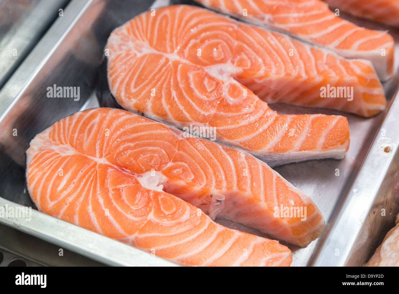 Darnes de saumon cru sur la boîte de métal en vitrine Banque D'Images