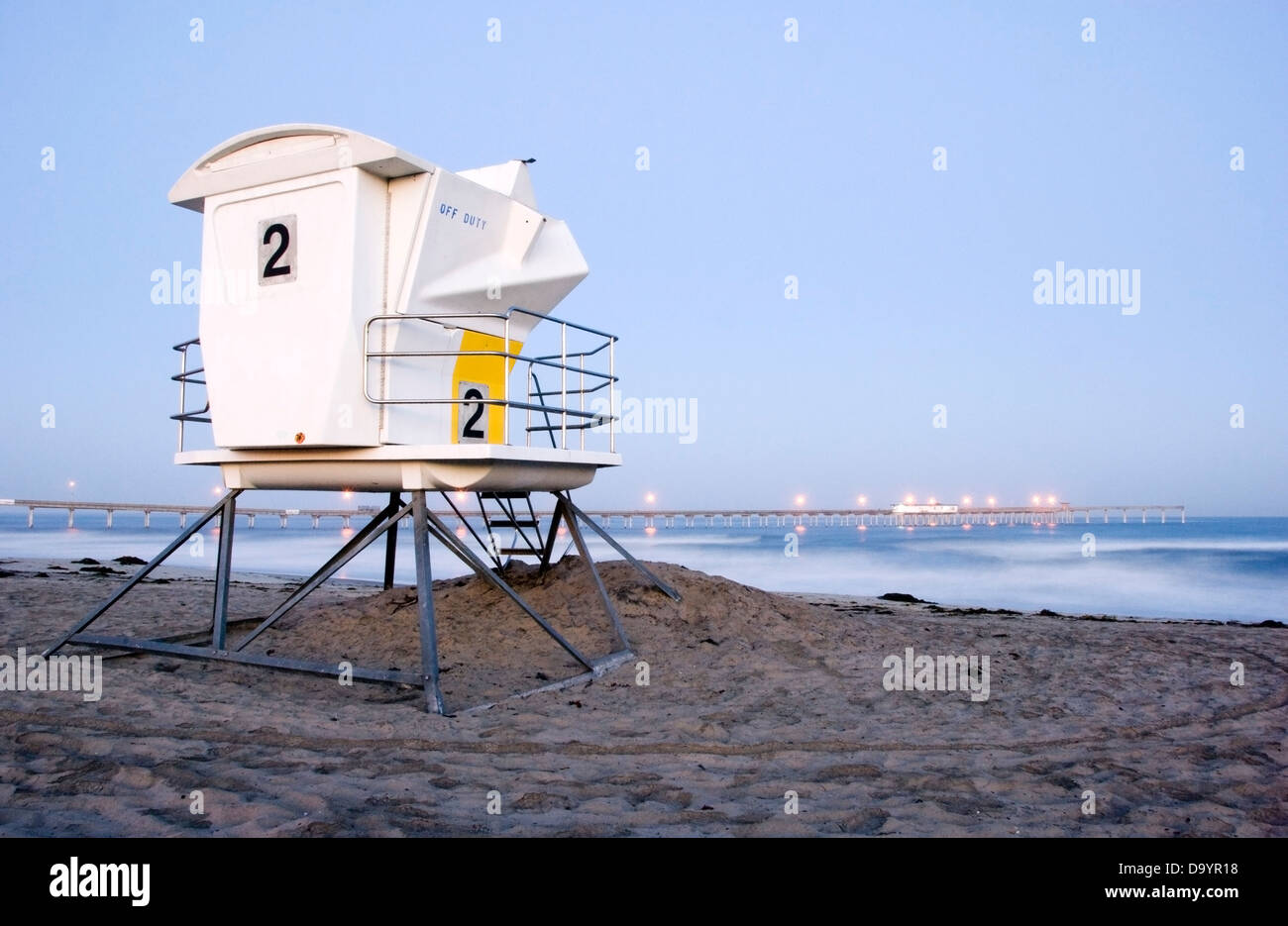 Un sauveteur Tower se trouve sur la plage au crépuscule avec le Ocean Beach Pier dans l'arrière-plan à San Diego, CA. Banque D'Images