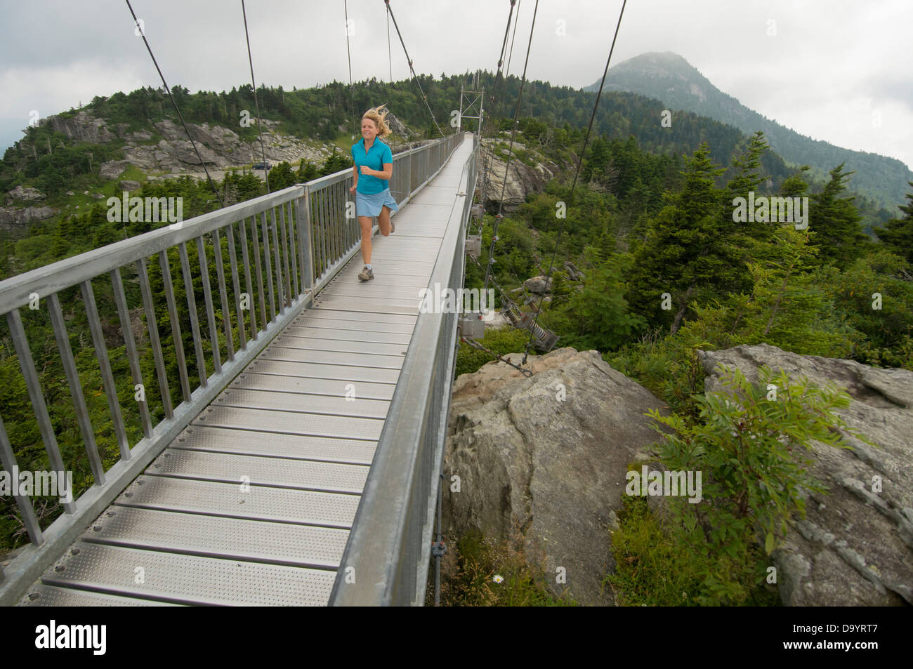 Une femme en travers de suspension bridge à Grandfather Mountain, Linville, Caroline du Nord. Banque D'Images