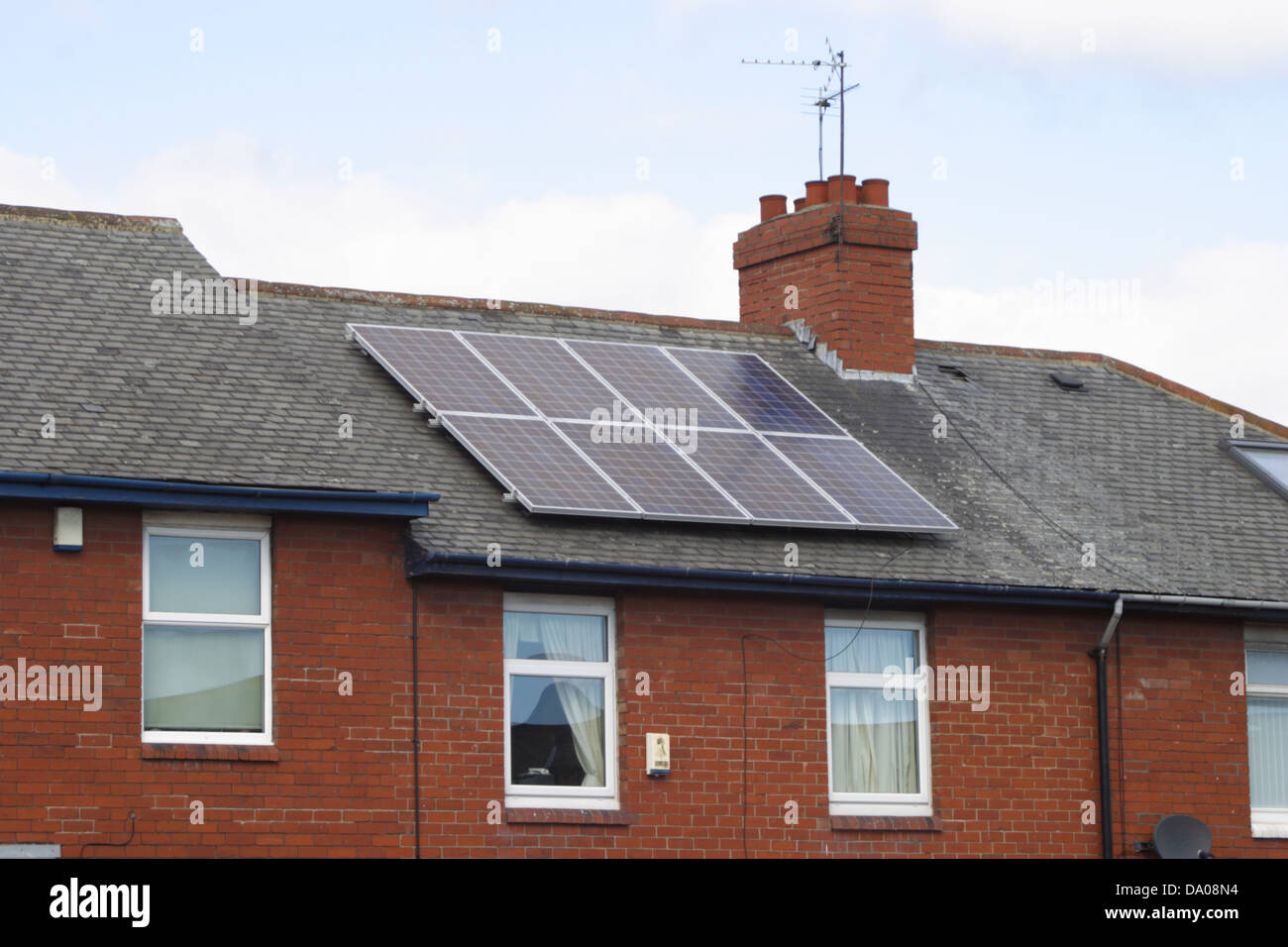 Des panneaux solaires sur le toit d'une maison au milieu de trois dans une rue à Sunderland. Banque D'Images