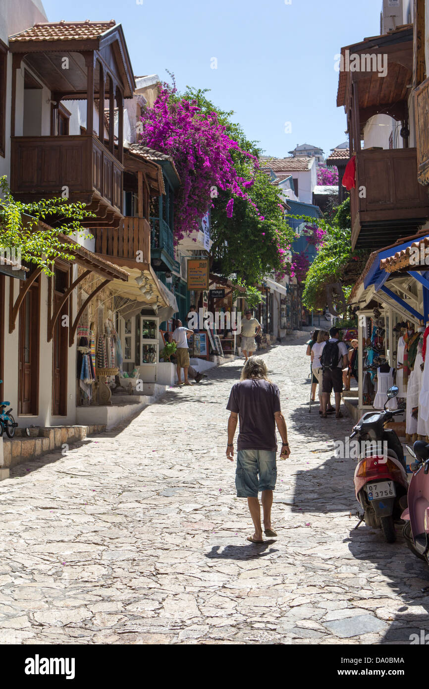 Un homme marche vers le haut de la rue principale de Kas, Turquie Banque D'Images