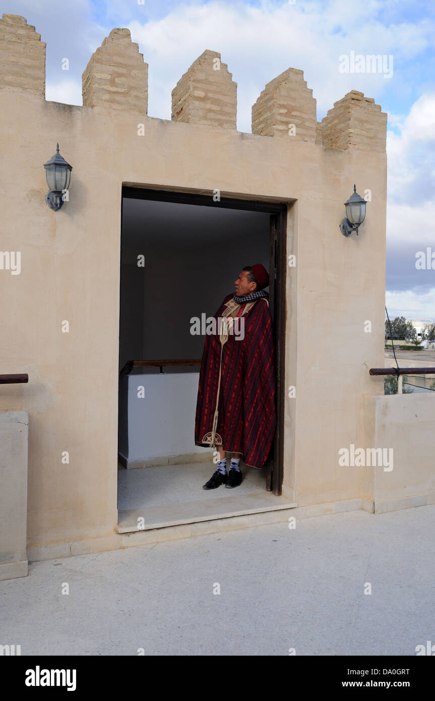 Homme portant des vêtements traditionnels tunisiens debout dans la porte d'une tour d'observation Kairouan Tunisie Banque D'Images