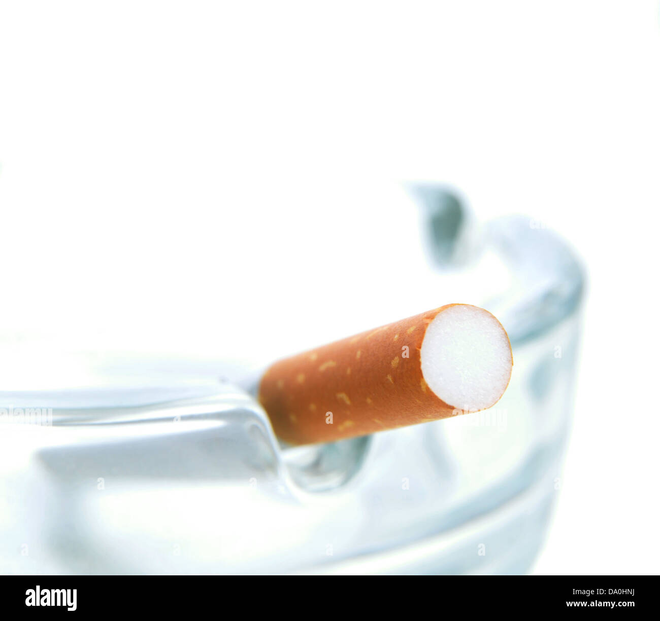 Cendrier en verre et cigarette sur fond blanc Banque D'Images