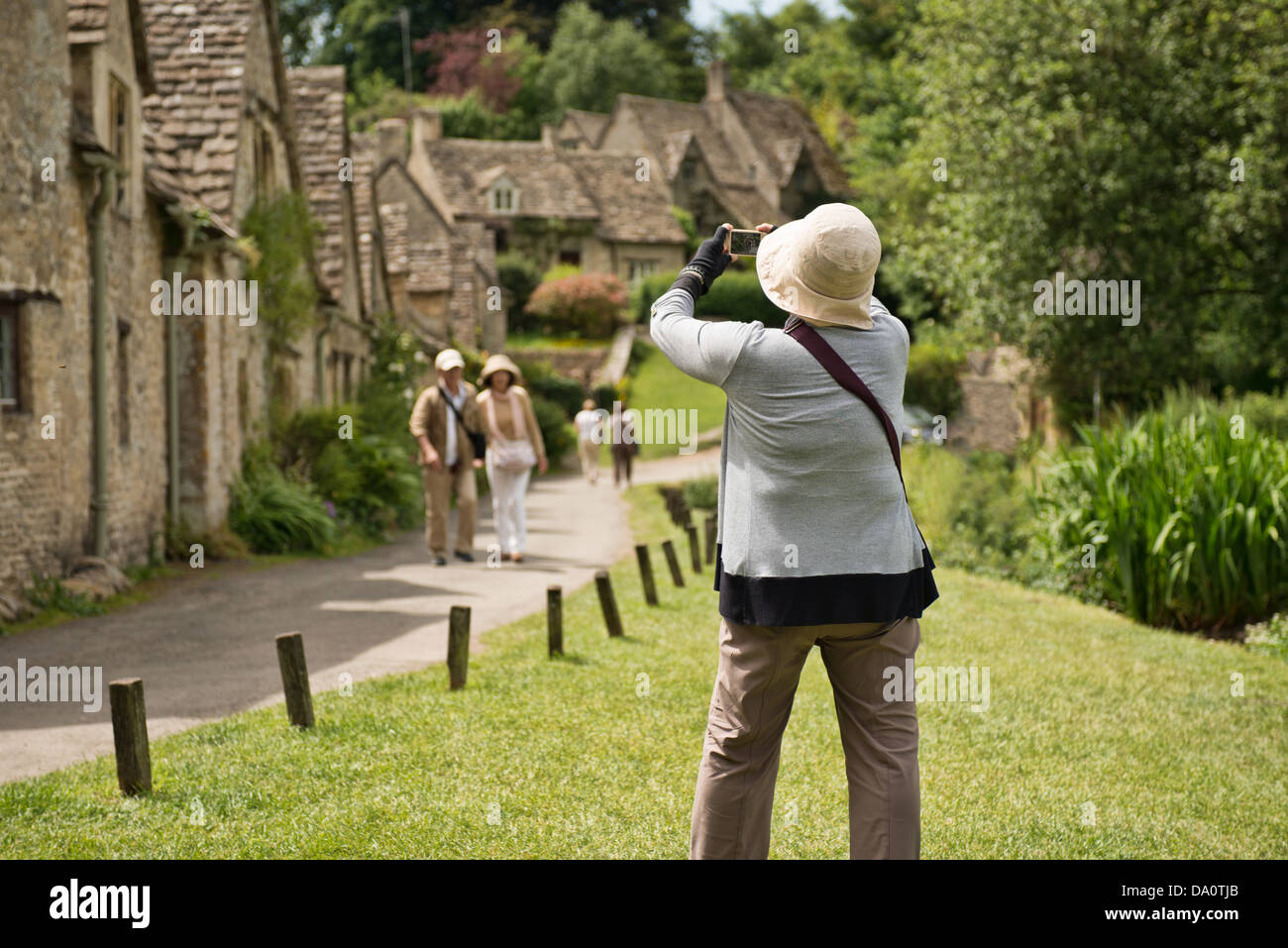 Un touriste asiatique de prendre une photo d'Arlington Row en Bibury, Gloucestershire, Royaume-Uni Banque D'Images