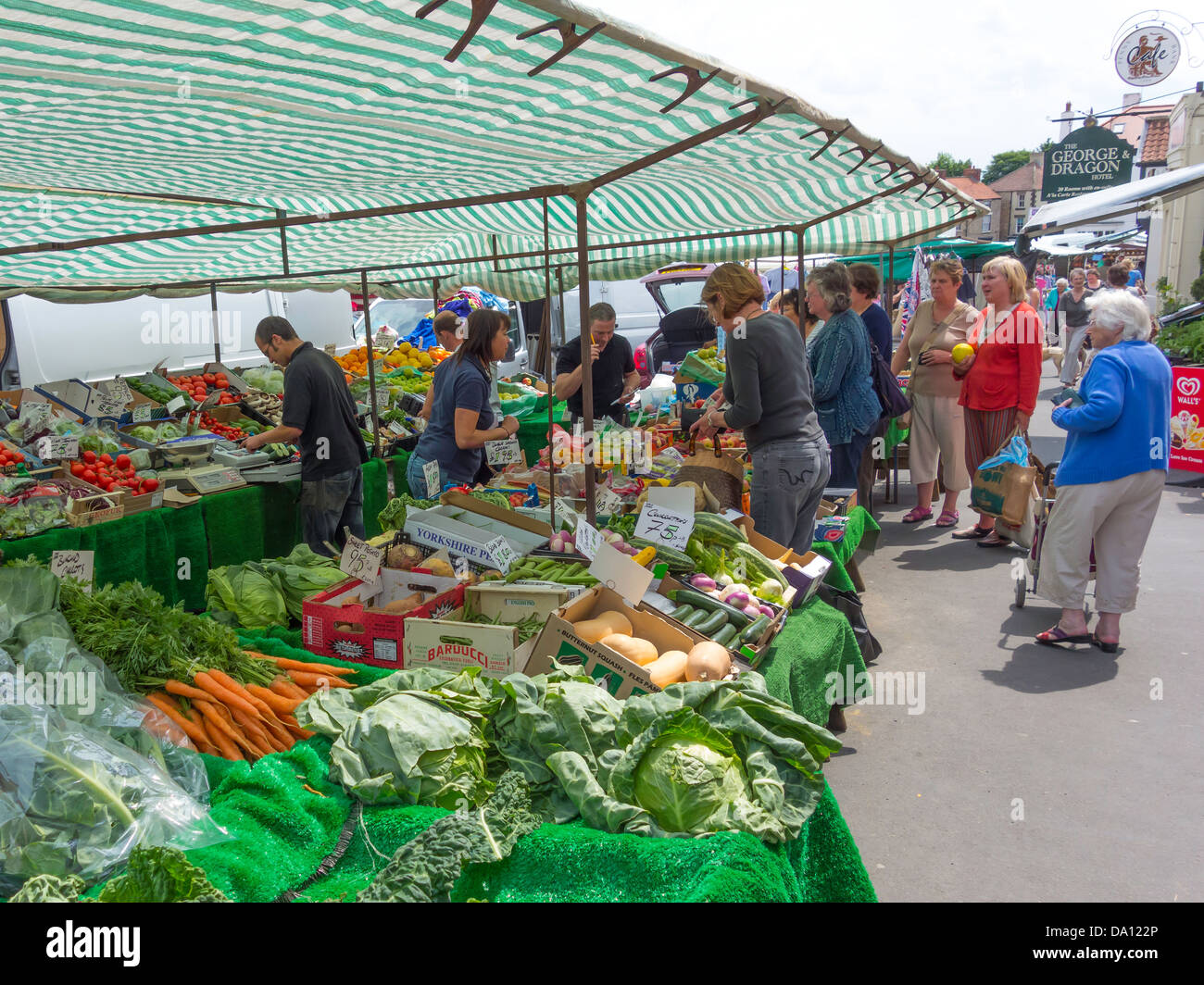 L'achat d'acheteurs de fruits et légumes d'un décrochage dans l'hebdomadaire de la rue du marché à Kirkbymoorside North Yorkshire Banque D'Images
