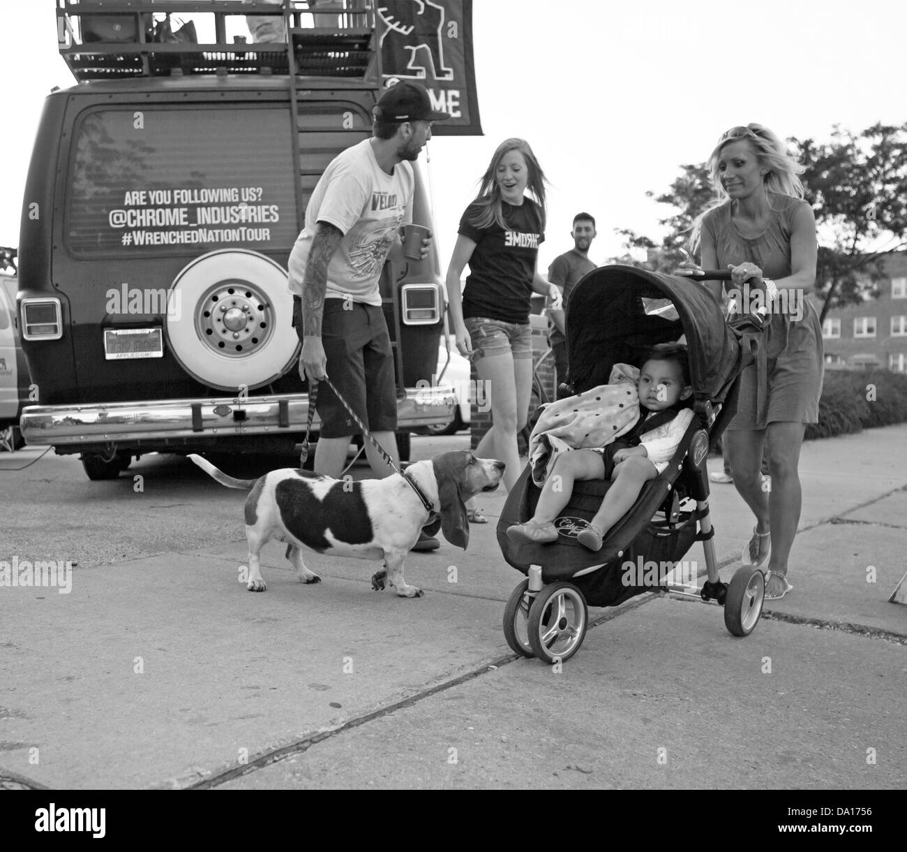 Un chien s'intéresse à un enfant en étant poussé dans une poussette. Banque D'Images