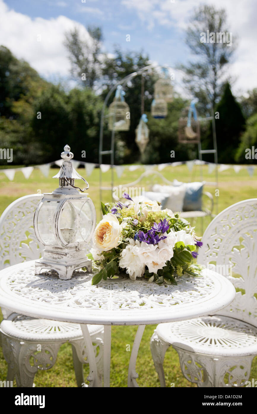 Jardin décoré pour votre réception de mariage avec bunting, lanternes et les cages à oiseaux dans un thème shabby chic vintage avec bouquet Banque D'Images