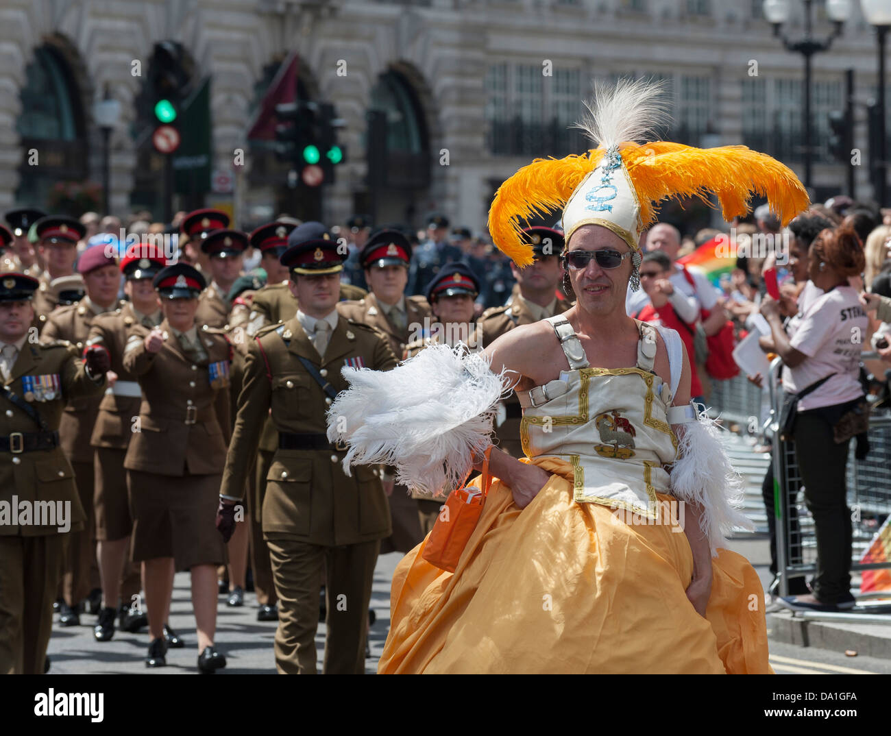 Un travesti marchant devant un contingent de l'armée dans la London Pride Parade. Banque D'Images