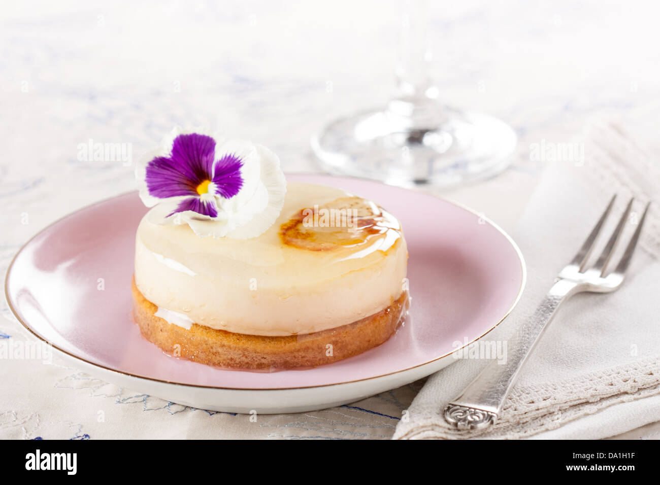 Gâteau au chocolat blanc individuel fantaisie sur table romantique décoré avec une fleur Banque D'Images