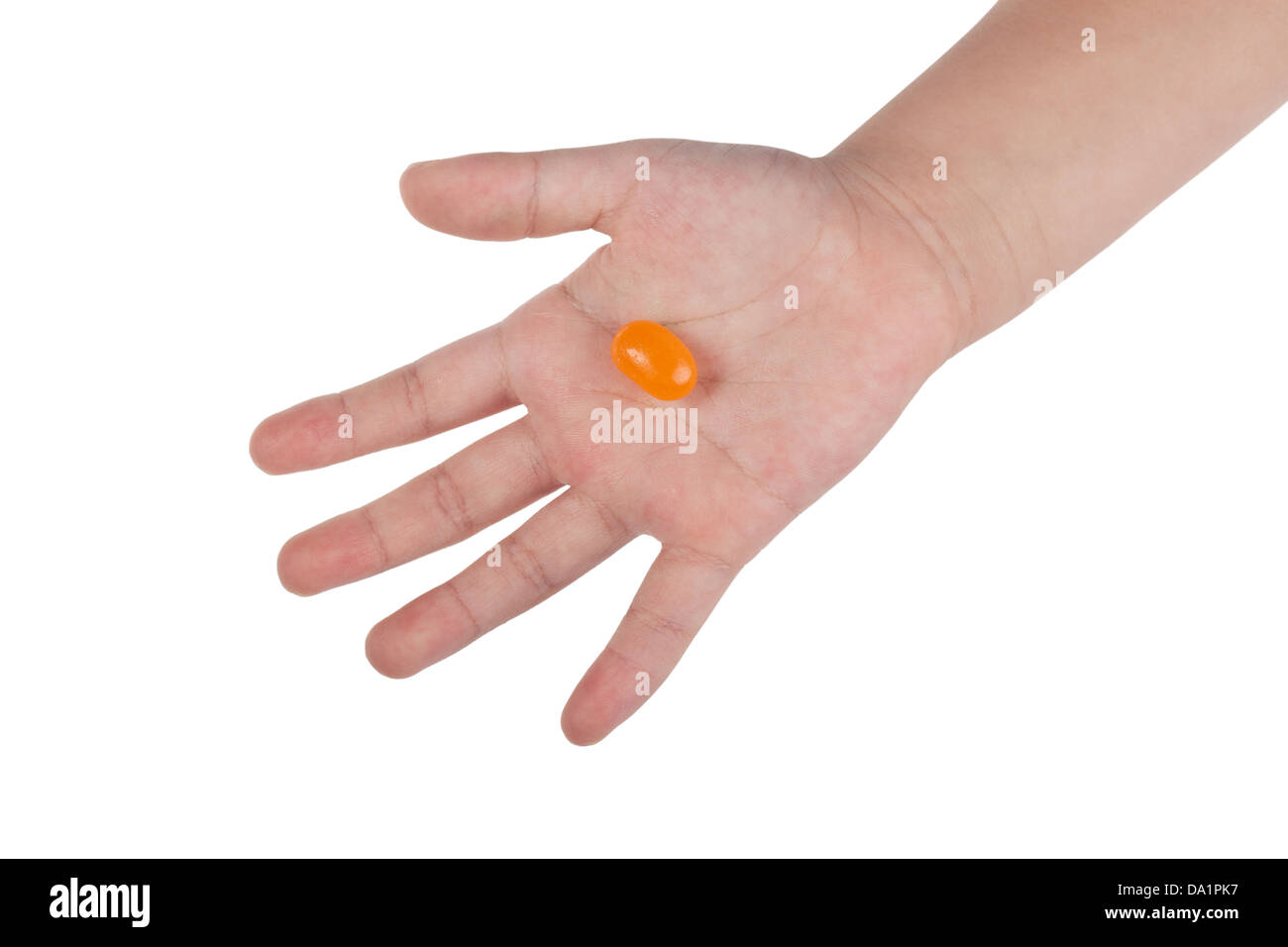 Seul jelly bean sur la main d'un enfant isolé sur fond blanc Banque D'Images