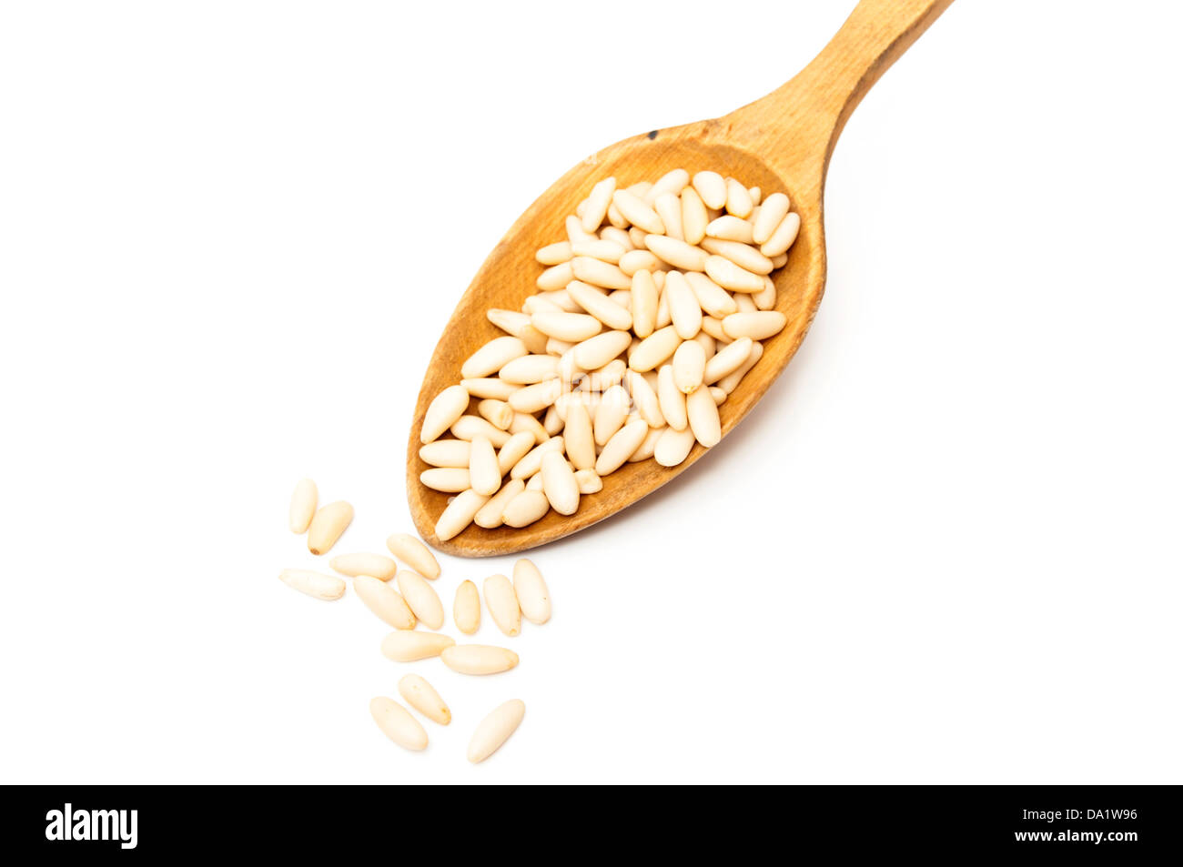Avec une cuillère les pignons de pin sur fond blanc Banque D'Images