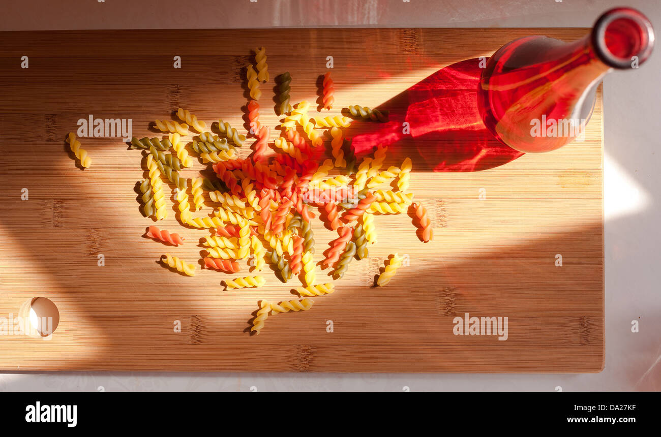 La vie toujours avec des pâtes colorées et glasss de vin rouge bouteille colorée et dans l'éclairage naturel. Banque D'Images