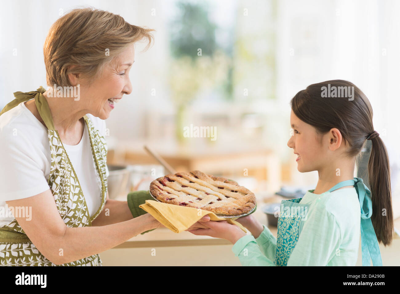 Grand-mère et petite-fille (8-9) holding freshly baked pie Banque D'Images