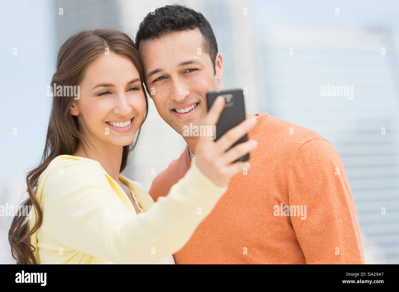 Jeune couple photographing themselves with mobile phone Banque D'Images