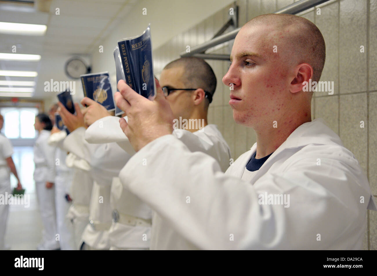 Les nouveaux étudiants de l'Académie navale américaine connue sous le nom de l'étude à partir de la plèbe Reef Points au cours de journée d'intégration le 27 juin 2013, à Annapolis, MD. Journée d'intégration commence lorsque la plèbe entrants sont émises des uniformes, étant donné les examens médicaux, l'enregistrement complet, recevoir des coupes de cheveux et apprenez à saluer. Banque D'Images