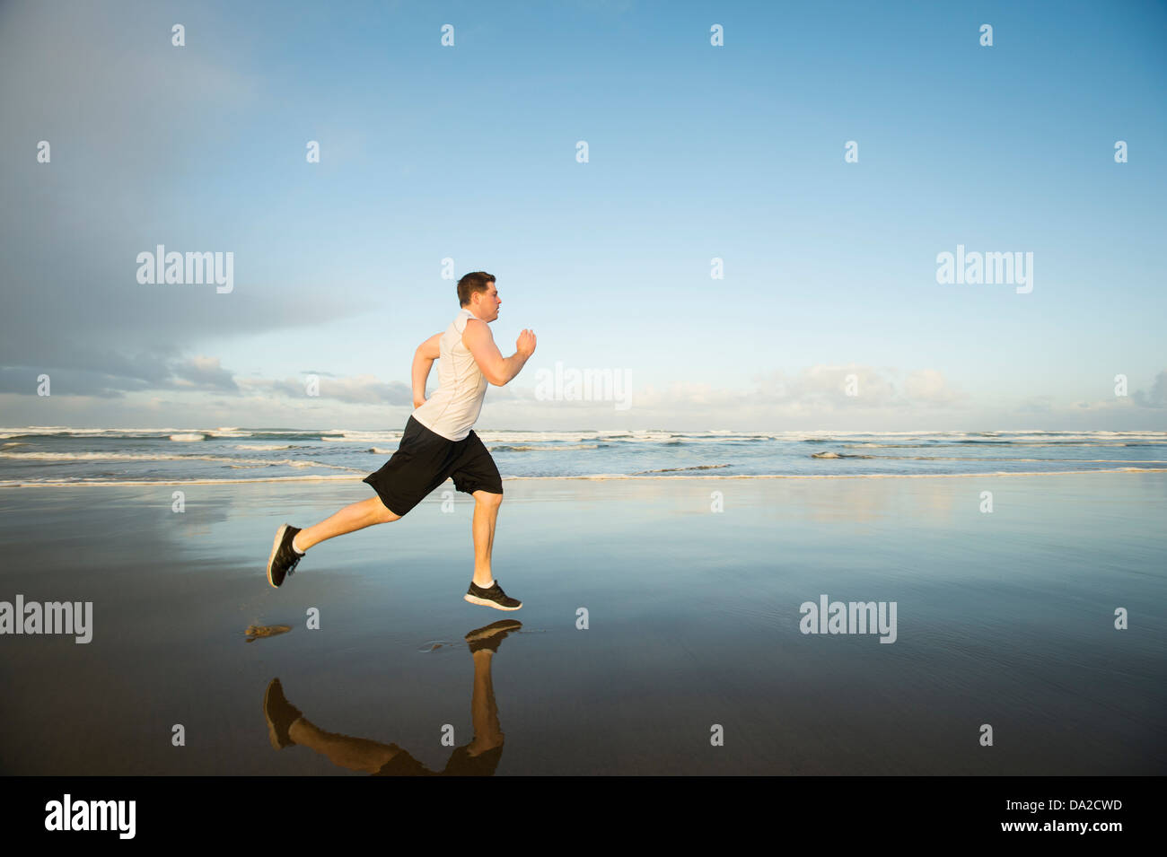 USA, Ohio, Rockaway Beach, Young adult man running on beach Banque D'Images