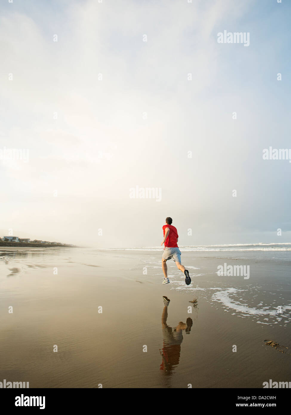 USA, Ohio, Rockaway Beach, Young adult man running on beach Banque D'Images