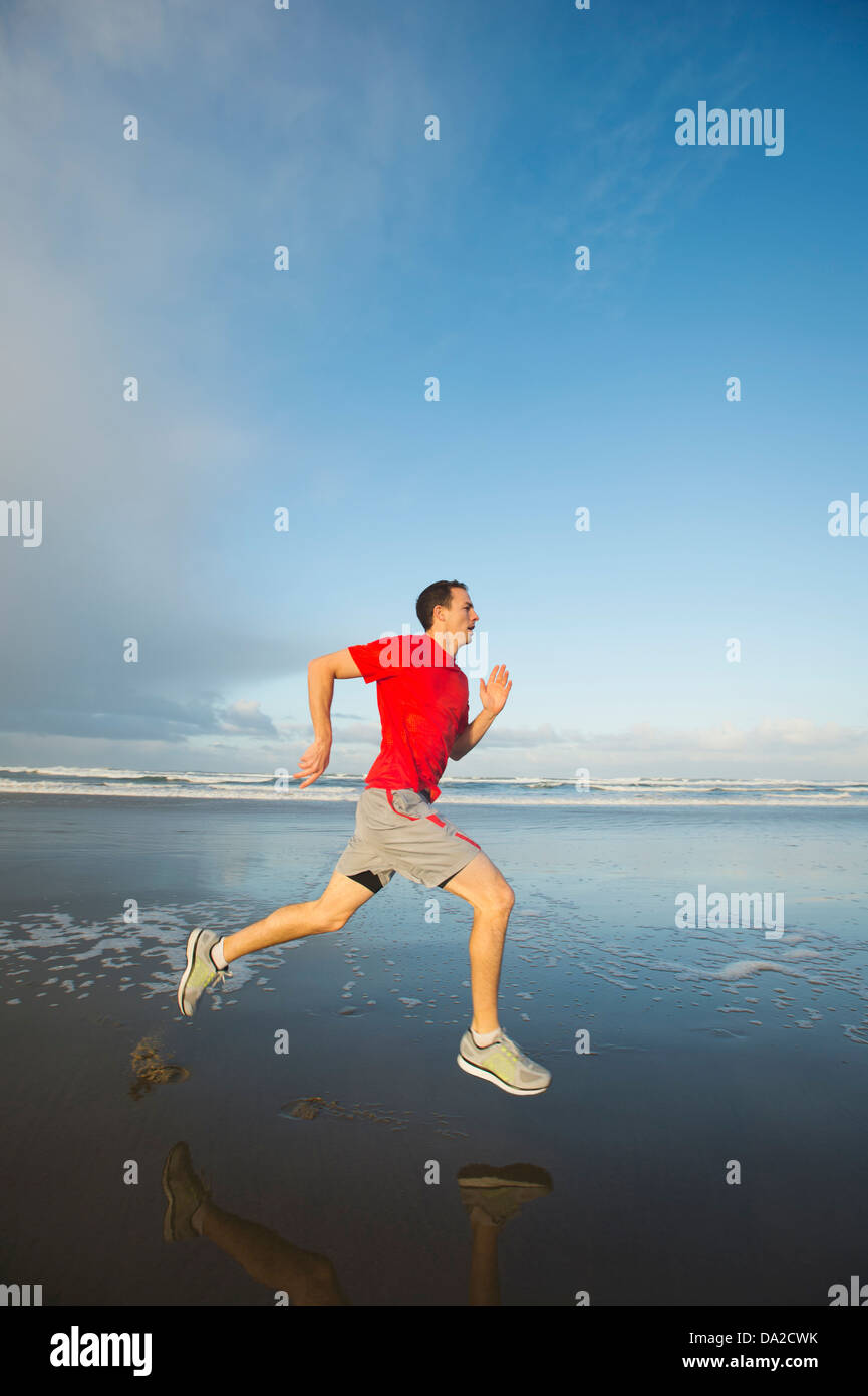 USA, Ohio, Rockaway Beach, Young adult man running on beach Banque D'Images