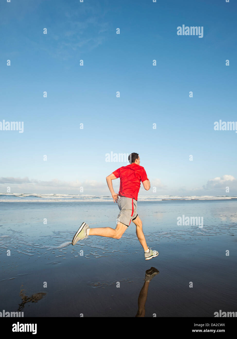USA, Ohio, Rockaway Beach, Young adult man running on beach Banque D'Images