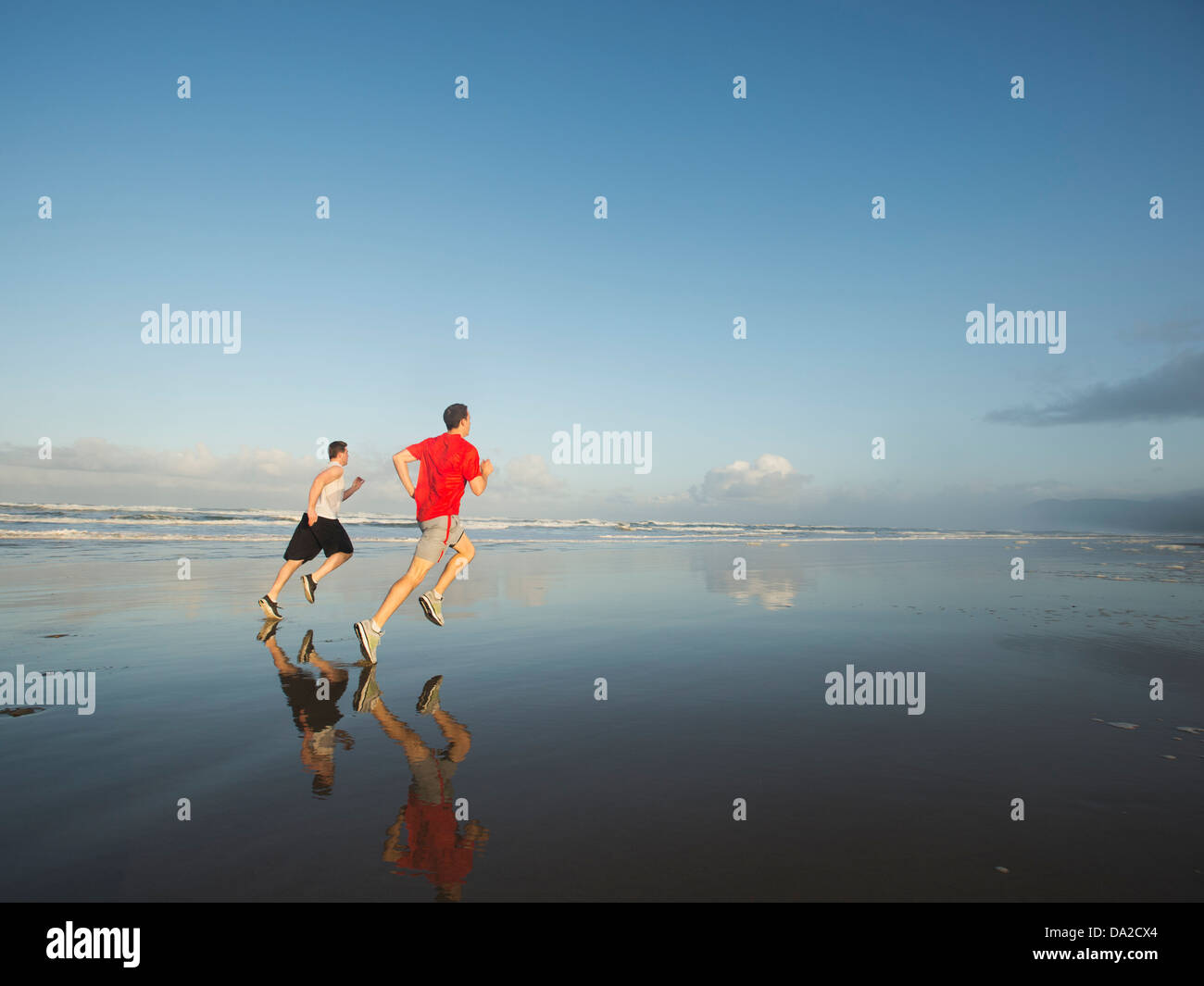 USA, Ohio, Rockaway Beach, les jeunes hommes adultes running on beach Banque D'Images