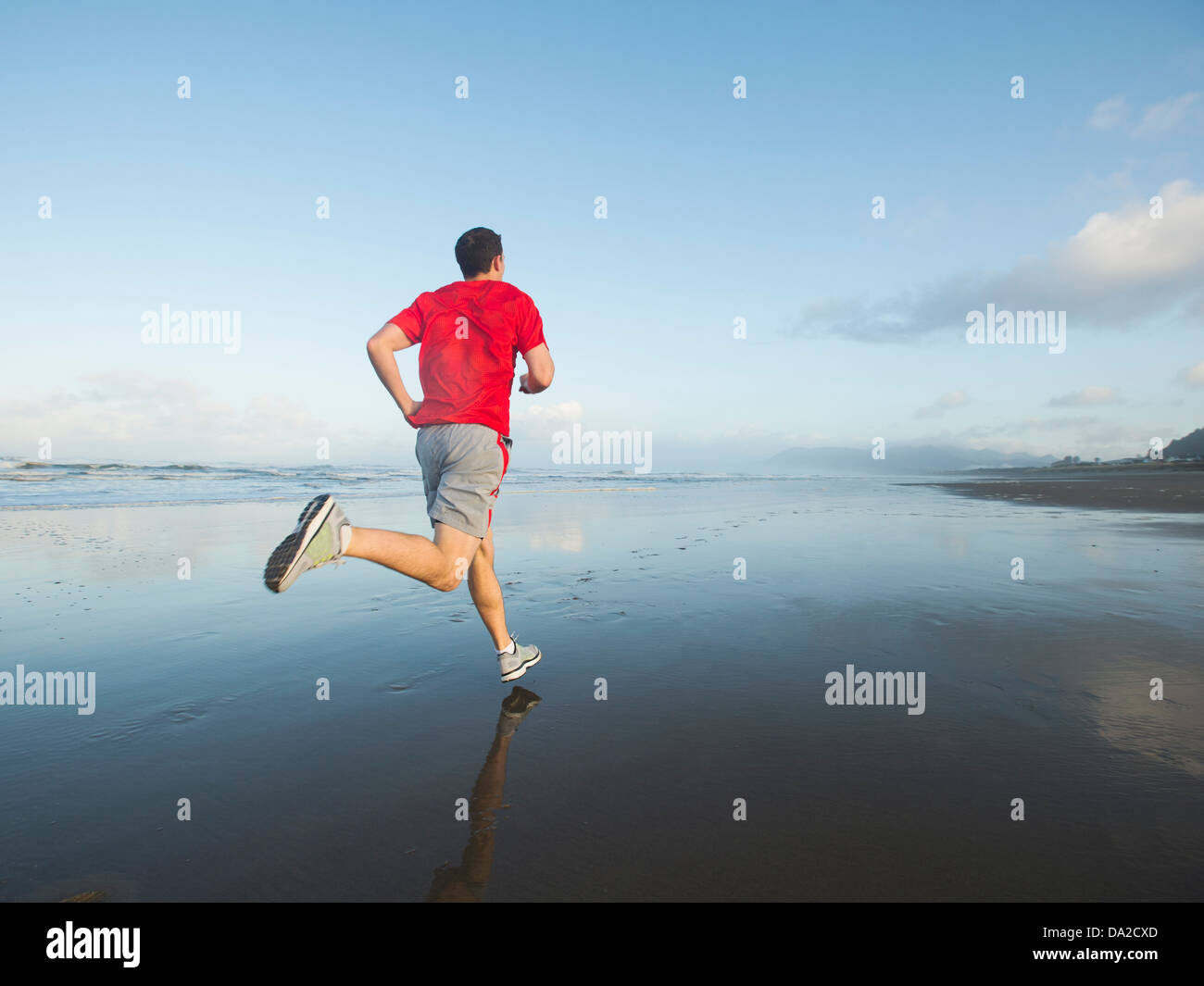 USA, Ohio, Rockaway Beach, Young adult man running on beach Banque D'Images
