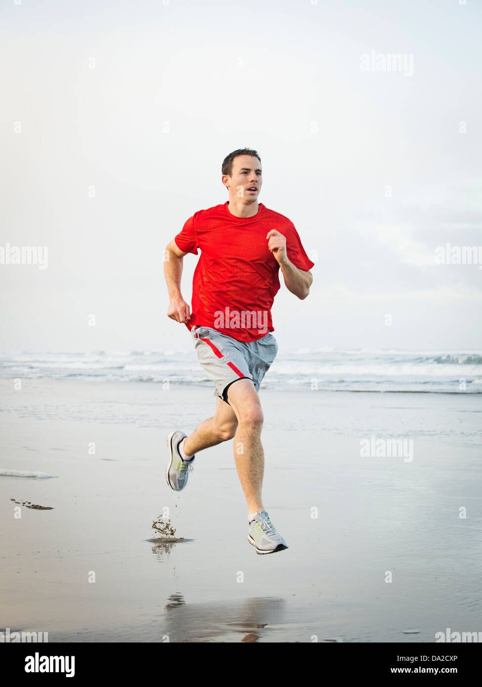 USA, Ohio, Rockaway Beach, Young adult man running on beach Banque D'Images