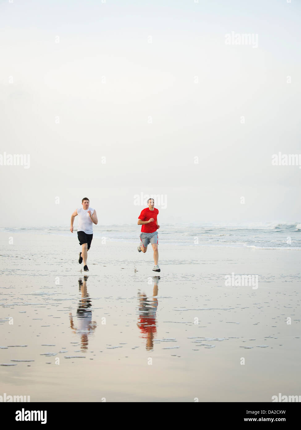 USA, Ohio, Rockaway Beach, les jeunes hommes adultes running on beach Banque D'Images