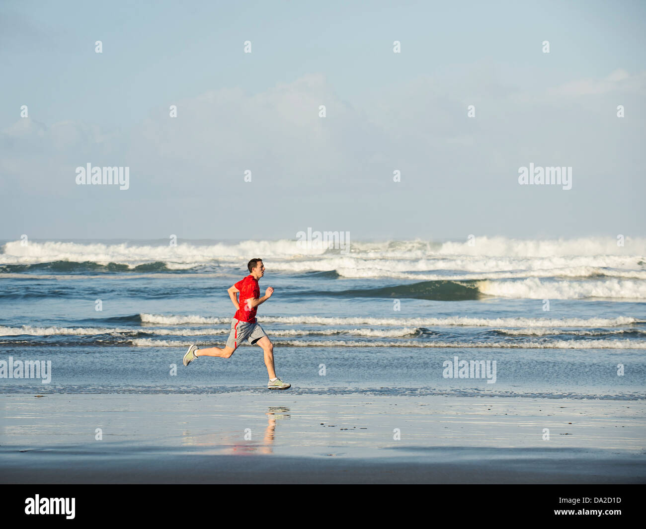 USA, Ohio, Rockaway Beach, Young adult man running on beach Banque D'Images
