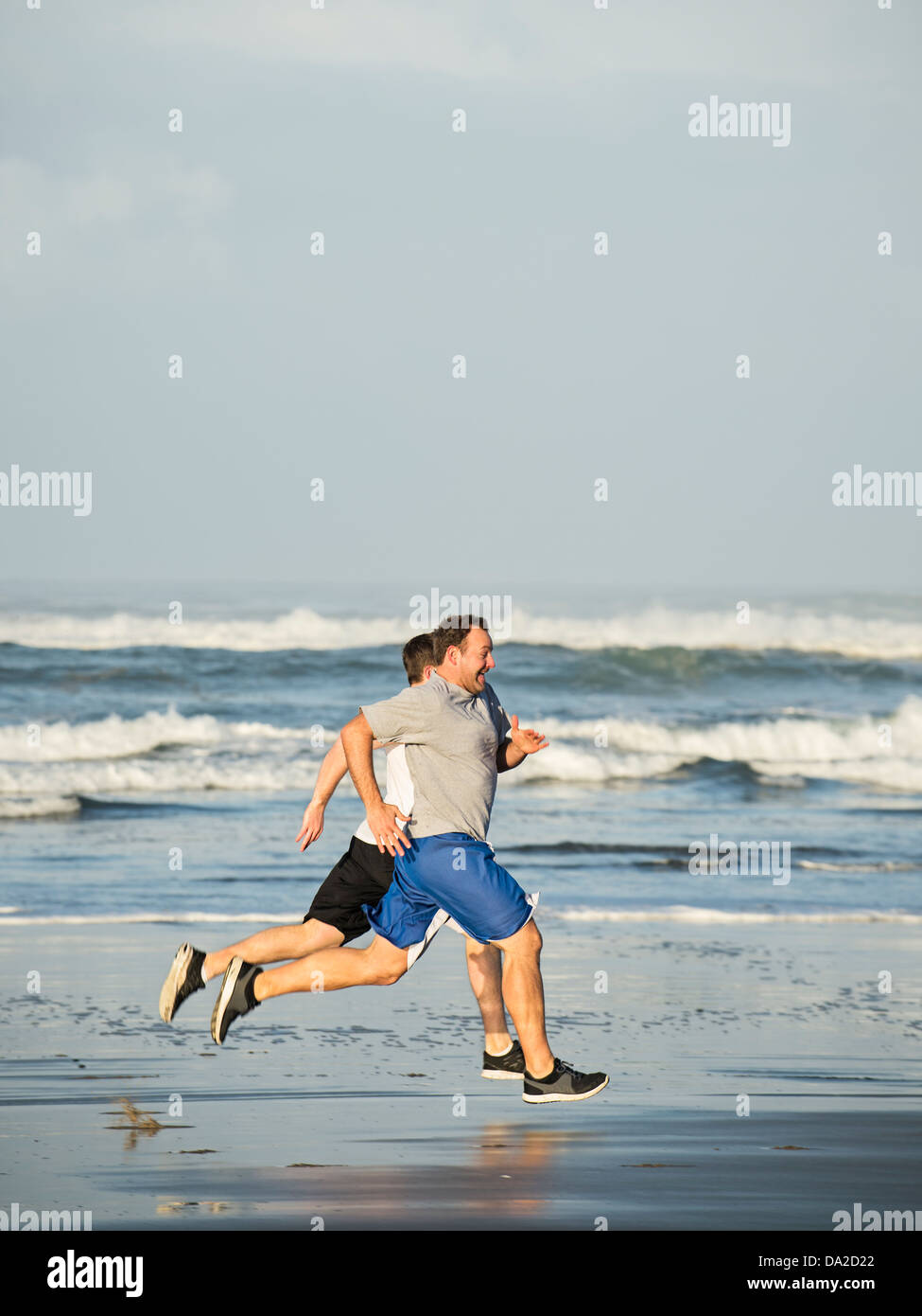 USA, Ohio, Rockaway Beach, les hommes running on beach Banque D'Images