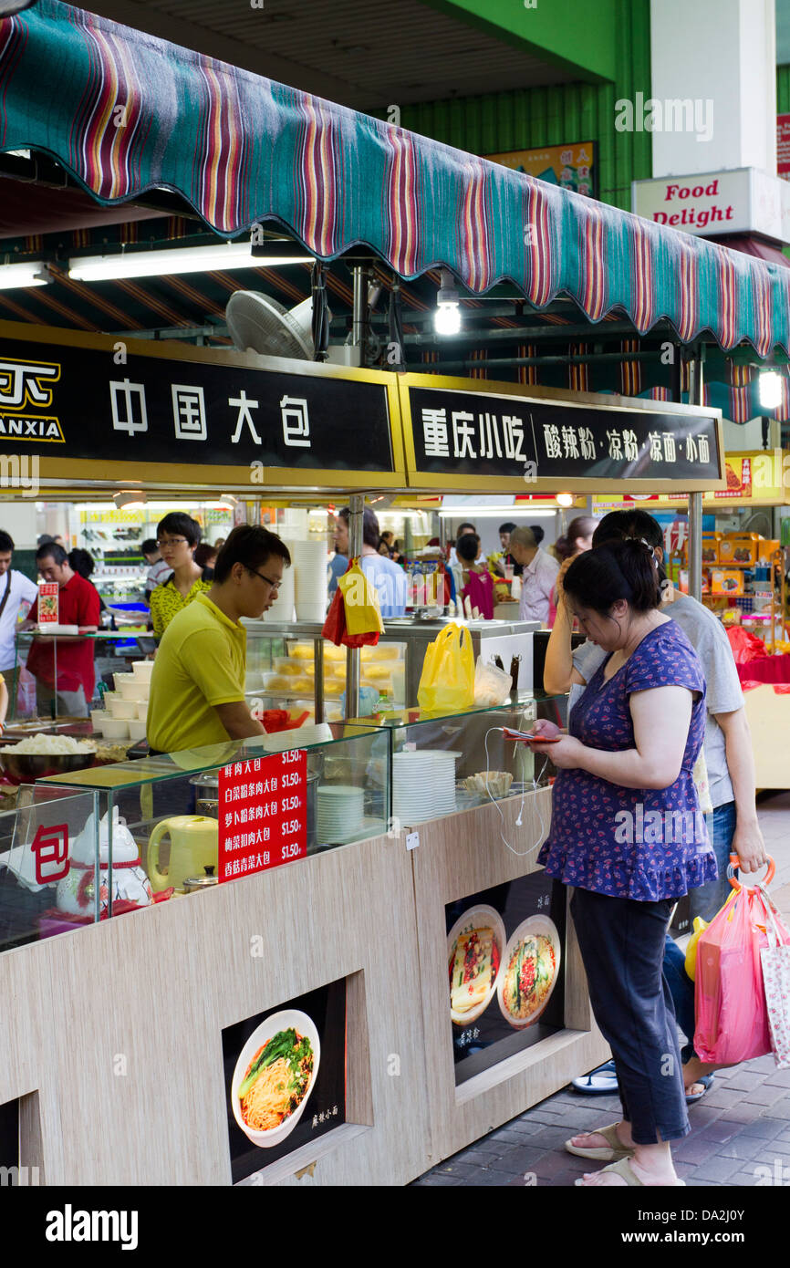 Les gens font la queue pour la nourriture chinoise chaude dans un food court, Chinatown, Singapour Banque D'Images